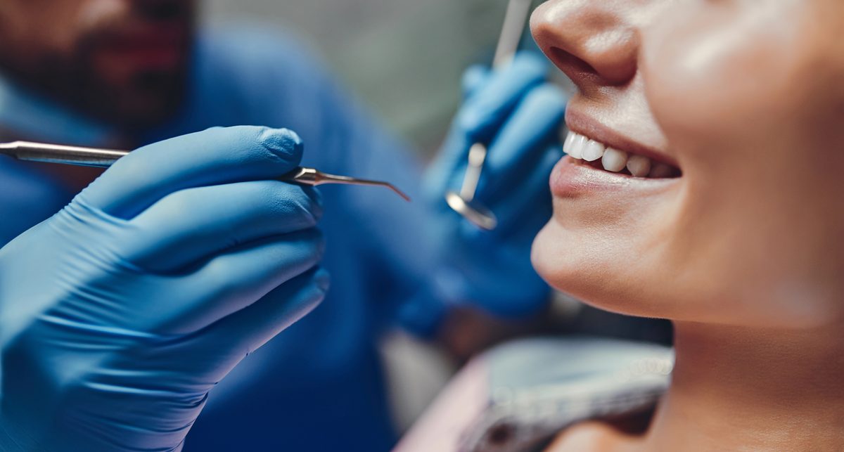 Dentist performing a checkup on a smiling patient