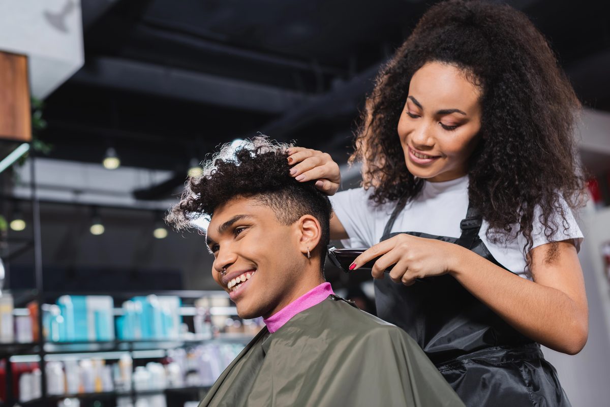 Hair stylist cutting a client's hair in a modern salon