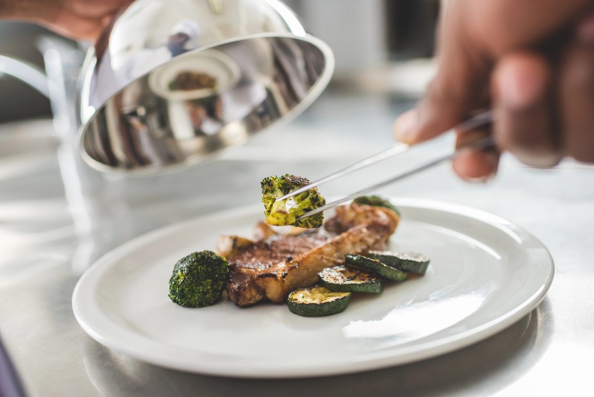 Chef plating a gourmet dish in a restaurant kitchen